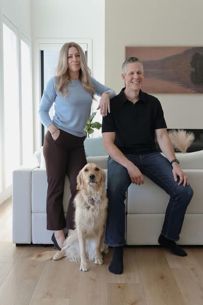 Robb Engen and Lindsay Engen with dog sitting on couch at home